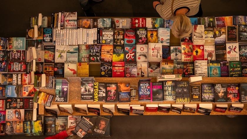 Bookstall featuring a wide range of genres including fiction, non-fiction, and romance, with readers engaging in exploration and discovery.