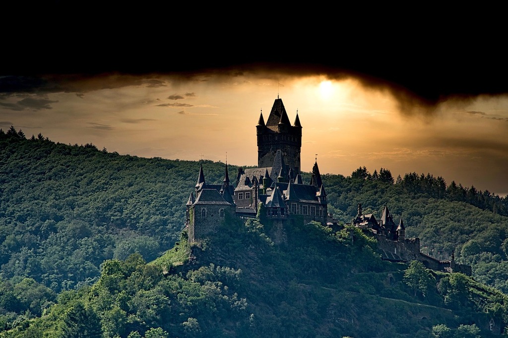Castle on a hill with a dramatic sunset backdrop.